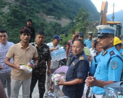 मुग्लिन–नारायणघाटमा अलपत्र परेका यात्रुहरुलाई खाजा र पानी वितरण गर्दै प्रहरी 